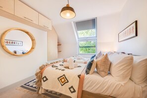 A bedroom with a bed, a round mirror, a window, and a ceiling light. - 3 Bed in St. Ives (oc-penlee) (Carbis Bay)