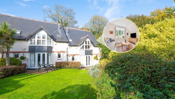 Ein zweistöckiges Haus mit gepflegtem Rasen und Garten.
