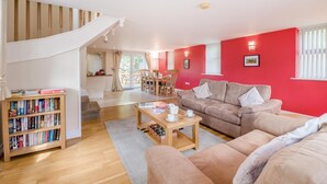 A spacious living room with a staircase, a dining area, and a bookshelf. - 2 Bed in Sledmere (oc-ey103) (Sledmere)