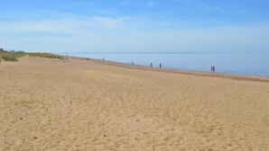 Una ampla platja de sorra sota un cel serè.