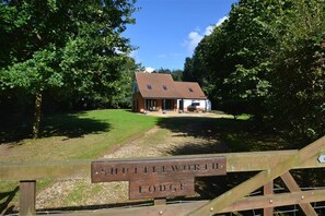 Une pancarte en bois portant l’inscription « Shuttleworth Lodge », indiquant un établissement proposant des hébergements.