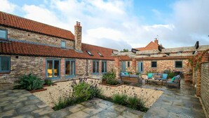 A courtyard with stone flooring, brick buildings, and outdoor seating. - 3 Bed in Holme-on-Spalding-Moor (oc-vy213) (Holme-on-Spalding-Moor)