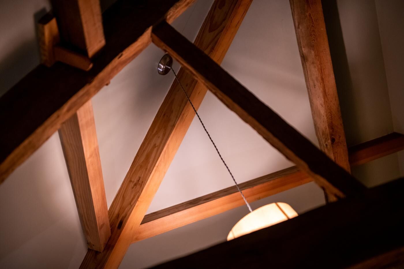 A wooden ceiling structure with a hanging light fixture.