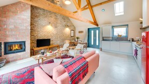 A cozy living room with a fireplace, a television, and a dining area. - 2 Bed in Holme-on-Spalding-Moor (oc-vy215) (Holme-on-Spalding-Moor)
