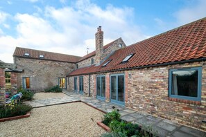 A brick building with a tiled roof, large windows, and a gravel courtyard. - 7 Bed in Holme-on-Spalding-Moor (oc-vy216) (Holme-on-Spalding-Moor)