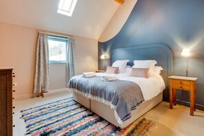 A bedroom with a large bed, a window with curtains, a nightstand, and a skylight. - 7 Bed in Holme-on-Spalding-Moor (oc-vy216) (Holme-on-Spalding-Moor)
