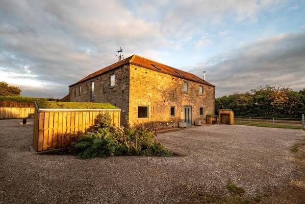 A two-story stone building with a gravel driveway, a wooden shed, and a fenced area. - 7 Bed in Holme-on-Spalding-Moor (oc-vy216) (Holme-on-Spalding-Moor)