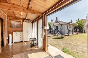 Interior de fusta amb vista a una casa i un jardí amb gespa.