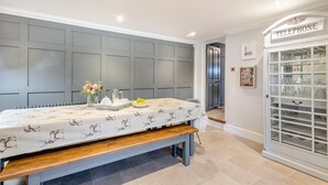 Une pièce avec une table mise pour le petit-déjeuner, un téléphone et un buffet vitré contenant de la vaisselle.