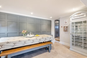 A room with a table set for breakfast, a telephone, and a glass cabinet with dishes. - 8 Bed in Bacton (oc-2383) (Bacton)