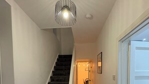 A staircase with carpeted steps leading to a landing, a light fixture above, and a door to the right. - 4 Bed townhouse Swansea city centre (Swansea)