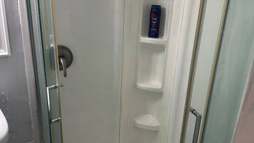 Een douche, handdoeken, zeep, toiletpapier