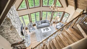 A spacious living area with a stone wall, a gray sofa set, and a coffee table.