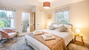 A bedroom with a large bed, a chair, a bedside table, and a window. - 2 Bed in Holt (oc-2377) (Holt)