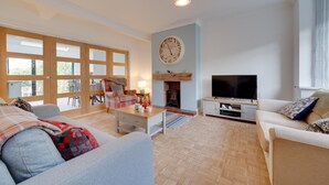 Una sala de estar con chimenea, televisor y zona de estar.
