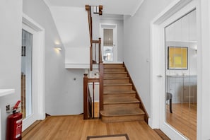 A staircase with wooden steps and a wooden handrail leading to an upper floor. - 4 Bed in Southwold (oc-stjam) (Southwold)