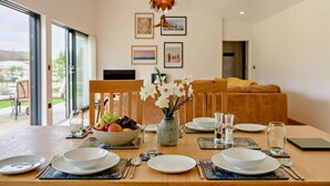 A dining table set with plates, cutlery, and a fruit bowl, with a vase of flowers and a candle centerpiece. - 2 Bed in Beckley (oc-rh1176) (Beckley)