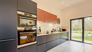 A modern kitchen with a built-in oven, a large window, and a view of the outdoors. - 2 Bed in Beckley (oc-rh1176) (Beckley)