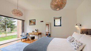 A modern bedroom with a large bed, a desk, and a chair. There is a window providing natural light and a view of the outdoors. - 2 Bed in Beckley (oc-rh1176) (Beckley)