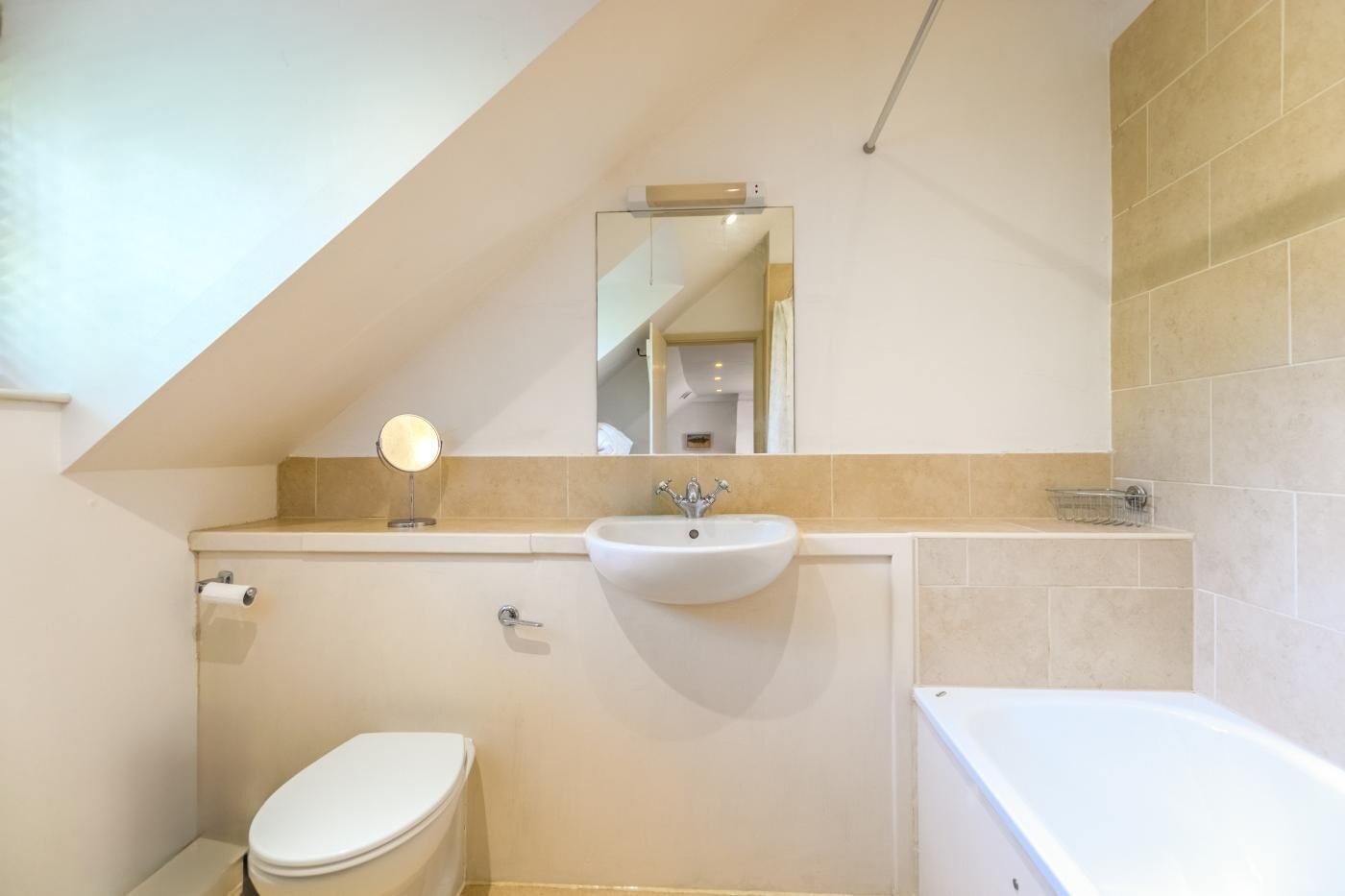 Een badkamer met toilet, wastafel en bad.