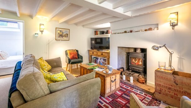 Un salón acogedor con sofá, sillón y chimenea.