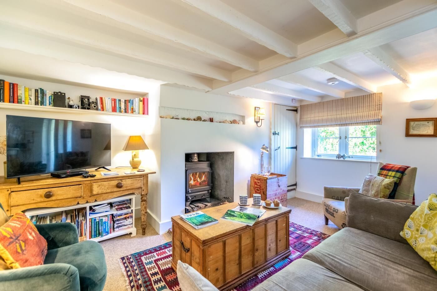 A cozy living room with a fireplace, bookshelves, a television, and a sofa.