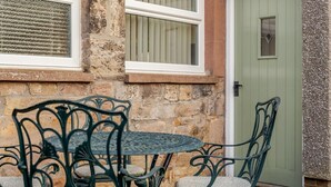 A stone building with a round table and four chairs. - 2 Bed in Chatton (oc-r27205) (Chatton)