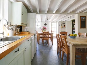 A kitchen with a wooden countertop, a sink, and a dining area with a table and chairs. - 4 Bed in Rock (oc-r27255) (Rock)