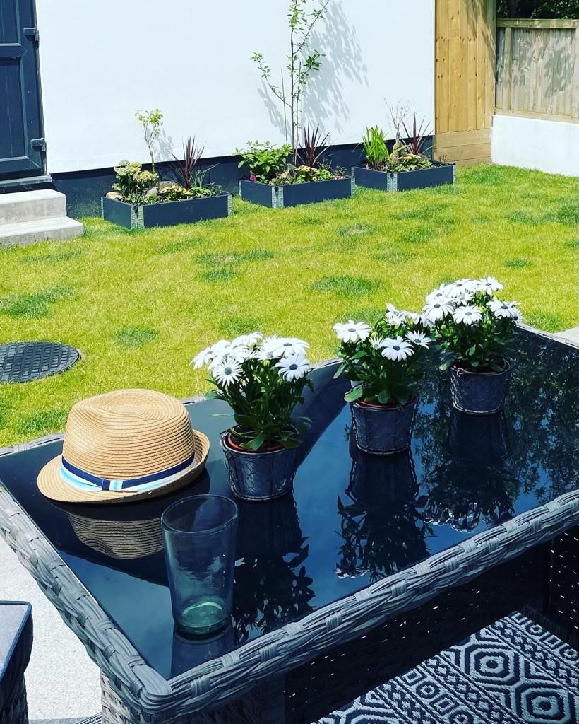 A glass table with potted plants and a straw hat.