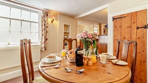 A dining area with a wooden table set for breakfast, including plates, cutlery, and a coffee pot. - 2 Bed in Yoxford (oc-c27253) (Wickham Market)
