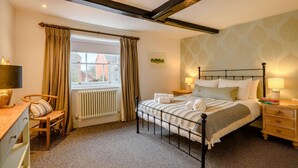 A bedroom with a bed, bedside tables, a desk, a chair, a radiator, and a window with curtains. - 2 Bed in Holt (oc-c27160) (Holt)