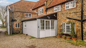 A stone building with a tiled roof, a small attached shed, and potted plants. - 2 Bed in Holt (oc-c27160) (Holt)