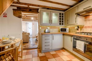 Una cucina con forno a microonde, fornello e pensili.