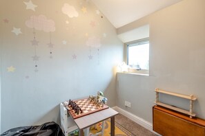 A child's playroom with a checkered floor, a wooden table, and a window with a view. - 3 Bed in Baslow (oc-h27288) (Baslow)