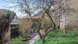 Um edifício de pedra com um caminho de jardim que leva a uma área de estar.