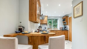 Uma cozinha moderna com armários de madeira, uma ilha central e vista para o exterior.
