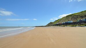 Ein Strand mit einer Reihe bunter Strandkörbe entlang der Küste.