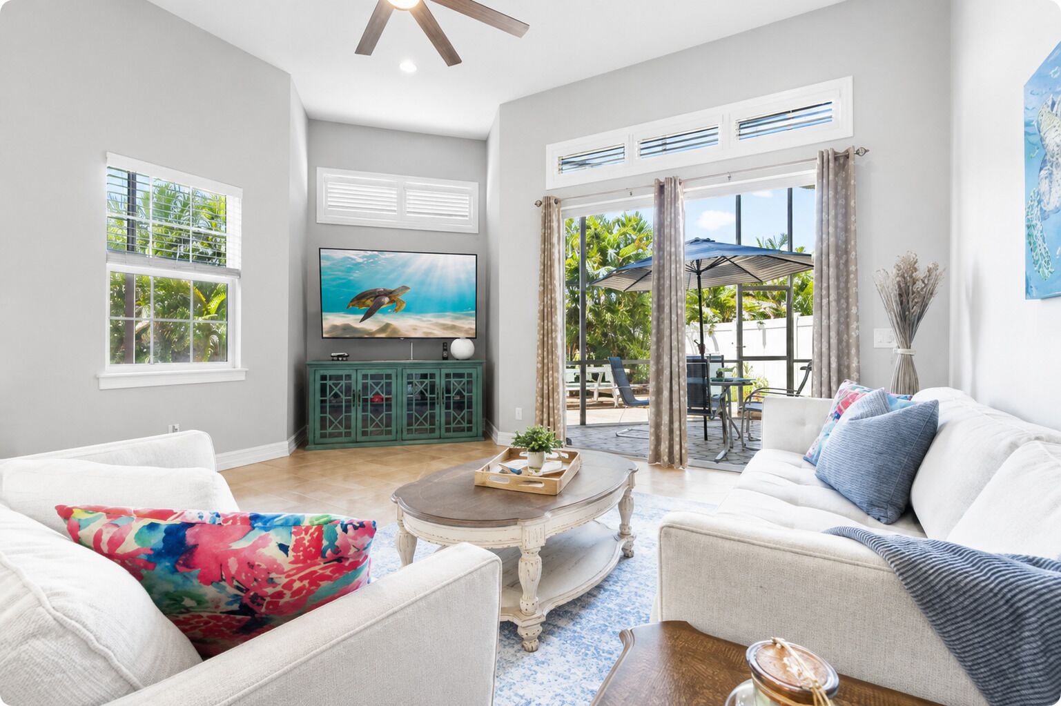 Un salon avec un téléviseur, une table basse et deux canapés.