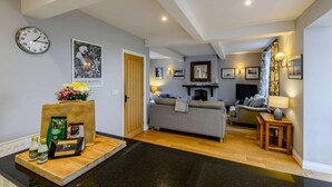 Ein modernes Wohnzimmer mit Sofa, Kamin und Essbereich mit Holztisch und Stühlen.