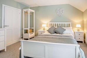 A bedroom with a bed, bedside tables, a wardrobe, and a hanging shelf. - 2 Bed in Mumbles (oc-t27408) (The Mumbles)