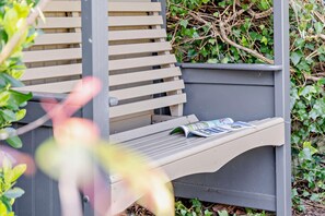 A bench with a magazine on it, surrounded by greenery. - 2 Bed in Mumbles (oc-t27408) (The Mumbles)