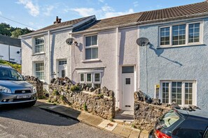 A two-story house with a stone facade, multiple windows, and a car parked in front. - 2 Bed in Mumbles (oc-t27408) (The Mumbles)