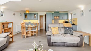 A modern apartment with a dining area, sofa, and kitchen. - 2 Bed in Sheringham (oc-b27372) (Sheringham)