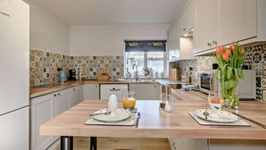 A modern kitchen with patterned backsplash, wooden countertops, and white cabinetry. - 2 Bed in Bale (oc-v27448) (Bale)