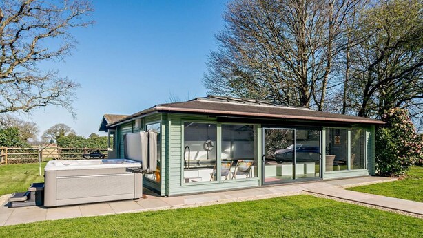 A glass-enclosed outdoor hot tub area with a built-in seating area and a hot tub. - 2 Bed in Bale (oc-v27448) (Bale)