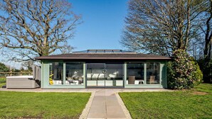 A modern glass-enclosed building with a flat roof, a patio area with chairs, and a small garden. - 2 Bed in Bale (oc-v27448) (Bale)
