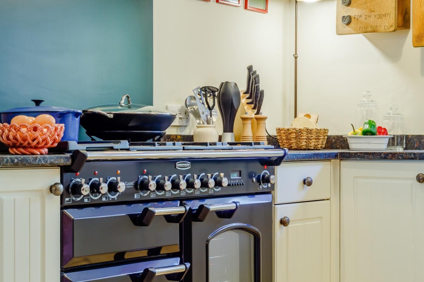 Une cuisine équipée d’une cuisinière, d’un four et de divers ustensiles de cuisine.