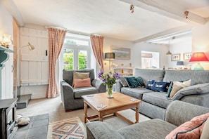 A cozy living room with a fireplace, a sofa, a coffee table, and a view of the outdoors. - 2 Bed in Weybourne (oc-h27517) (Weybourne)