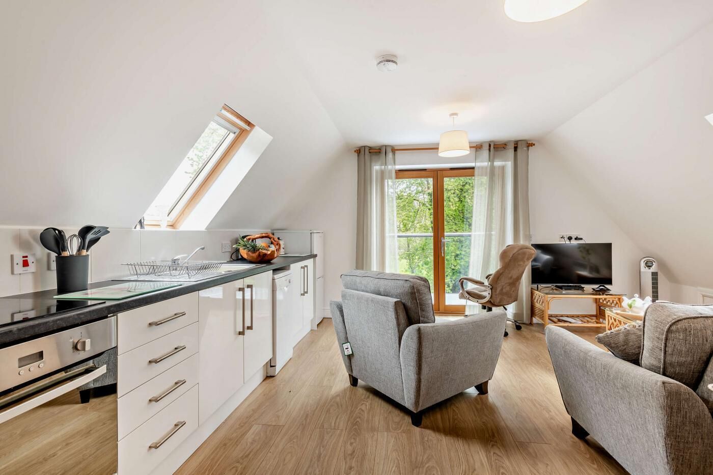 Un appartement moderne comprenant une cuisine, un coin repas et un salon.