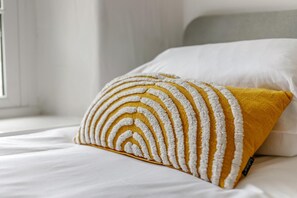 A bed with white bedding and a mustard-colored pillow with a textured pattern. - 2 Bed in St. Agnes (oc-h27472) (Saint Agnes)
